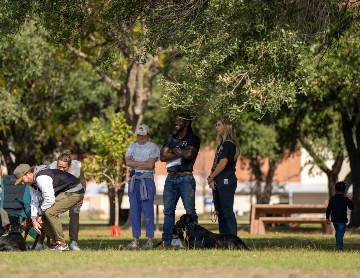 Emmanuel coaching owners and their dogs at a K9 Professor group session in a Houston park